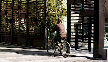 A cyclist rides past a hotel entrance with a large &ldquo;HOTEL CITRINE&rdquo; sign above the walkway.